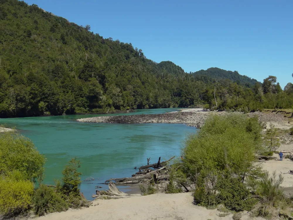 Agua verde y playa de arena en uno de los ríos del camino