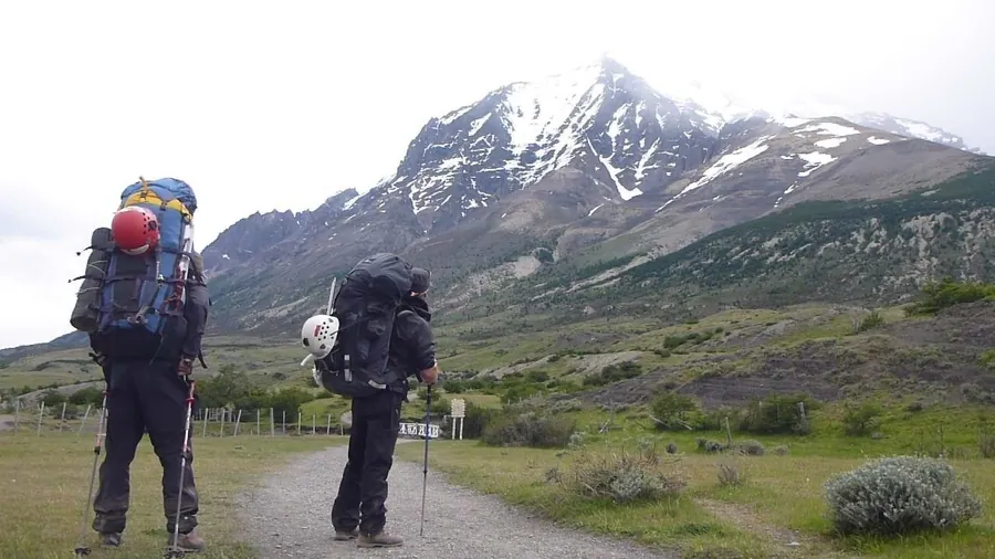 Dos caminantes con mochila en un sendero del parque